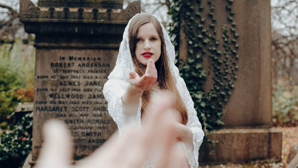 Photo of Dora in a cemetery holding her hand out to you. Photo by Seweryna Dudzinska.